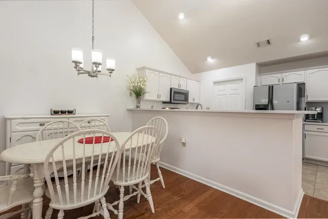 a dining room with furniture a chandelier and wooden floor
