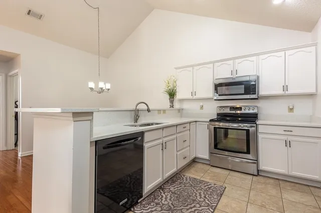 a kitchen with stainless steel appliances granite countertop a sink and a stove