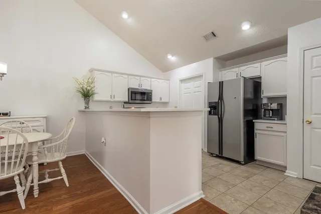 a kitchen with stainless steel appliances a refrigerator and a stove top oven