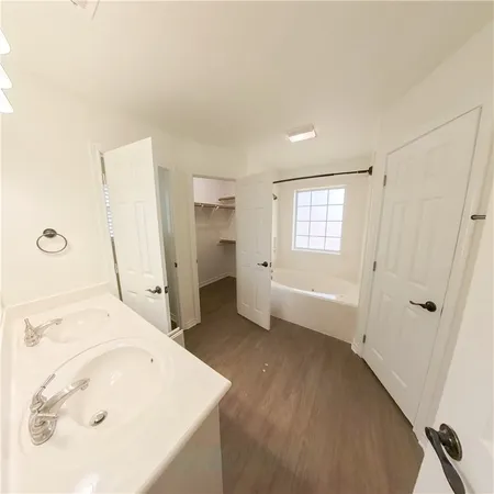 a bathroom with a granite countertop toilet a sink and a window
