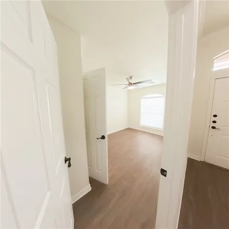 a view of a hallway with wooden floor