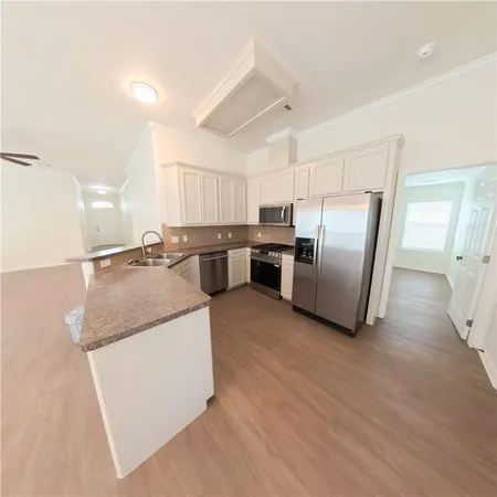 a kitchen with stainless steel appliances granite countertop a refrigerator a sink a stove and a refrigerator