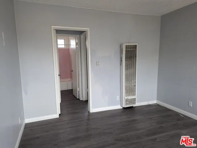 an empty room with wooden floor and closet
