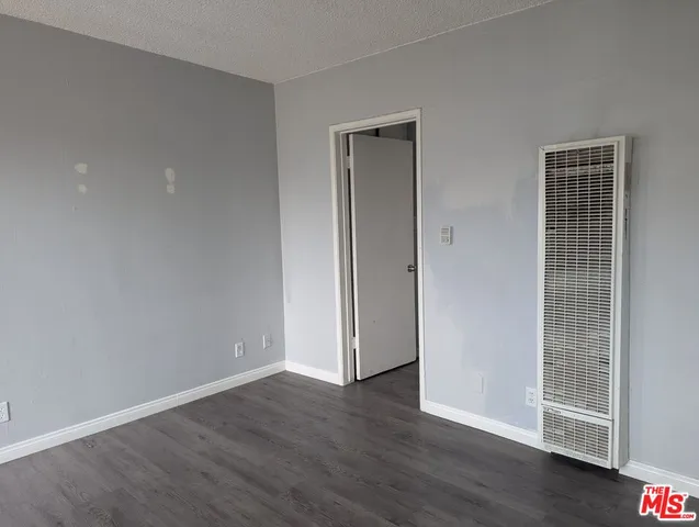 an empty room with wooden floor and closet