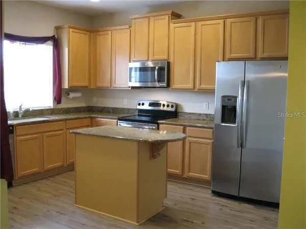 a kitchen with a refrigerator sink and cabinets