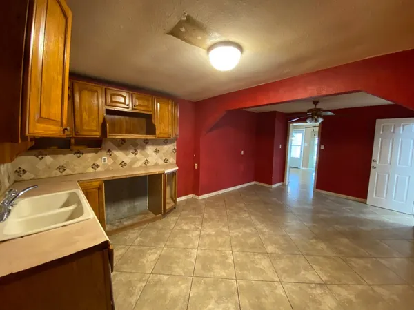 a view of a room with a ceiling fan and window