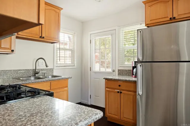 a kitchen with sink refrigerator and window