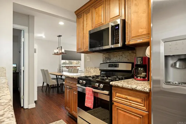 a kitchen with stainless steel appliances granite countertop a stove and a microwave