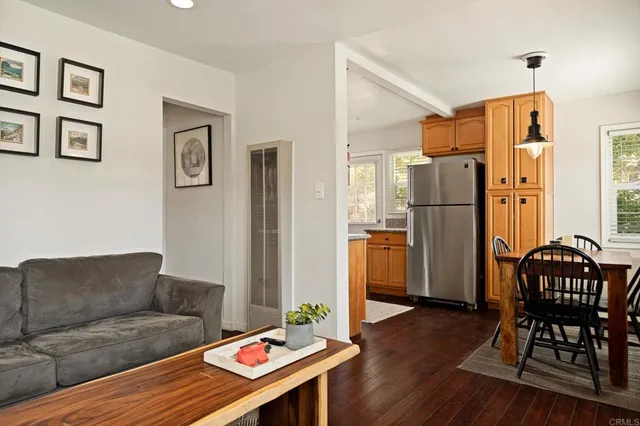 a living room with furniture and a refrigerator