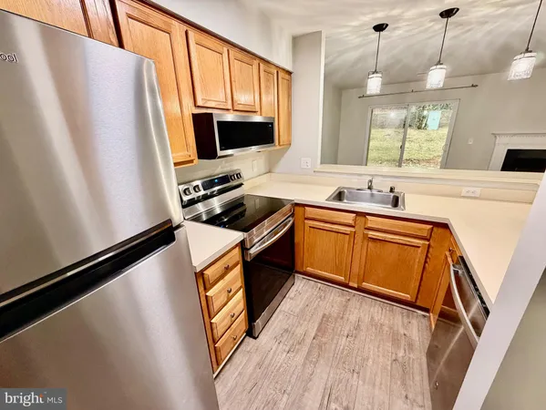 a kitchen with stainless steel appliances a stove a sink a refrigerator a window