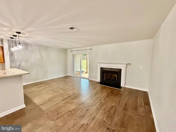 a view of an empty room with a fireplace and a window