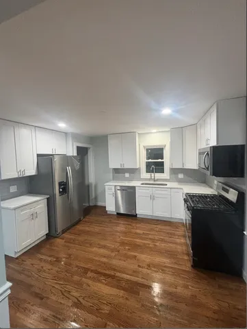 a large kitchen with cabinets and stainless steel appliances