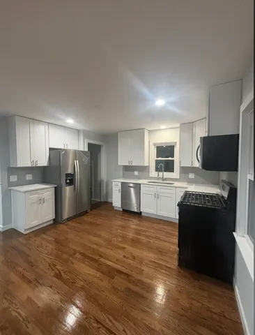 a large kitchen with cabinets and stainless steel appliances