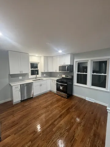 a large kitchen with cabinets a sink and a stove