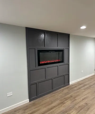 a living room with a wooden floor and a fireplace