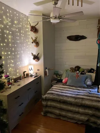 a bedroom with a bed a dresser and a large window