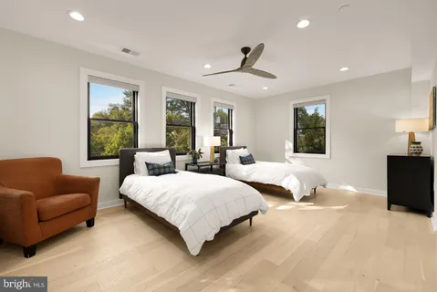 a view of a livingroom with a ceiling fan & windows