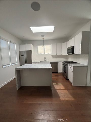 a large kitchen with kitchen island a sink stainless steel appliances and cabinets