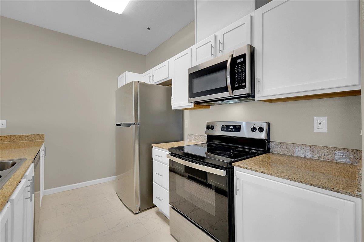 4200 East Commerce, Unit 1121 Sacramento, CA 95834 - Photo 8 of 24 a kitchen with stainless steel appliances a stove microwave and sink