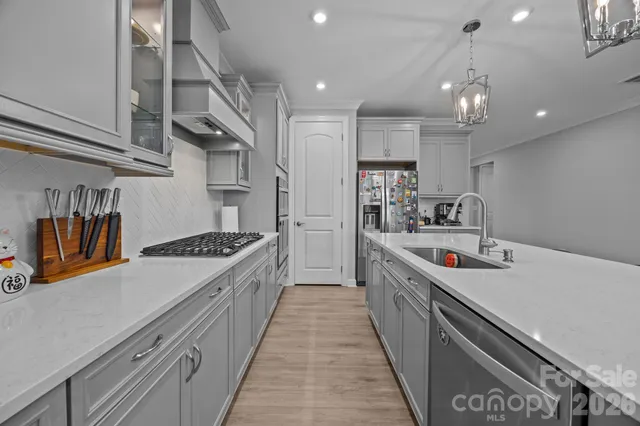 a kitchen with stainless steel appliances granite countertop a sink a stove and a refrigerator