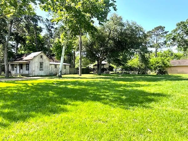 a view of house with swimming pool and green space