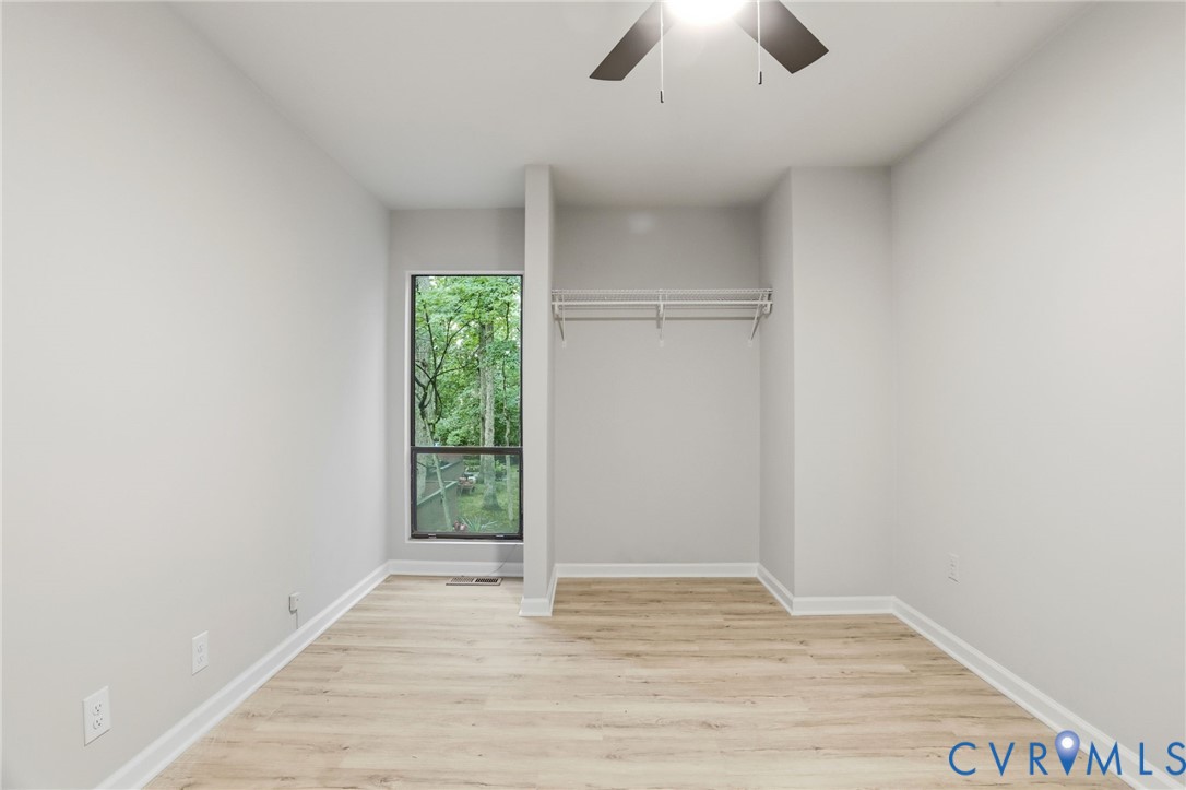 11735 South Briar Patch Drive Midlothian, VA 23113 - Photo 30 of 48 an empty room with wooden floor chandelier fan and windows