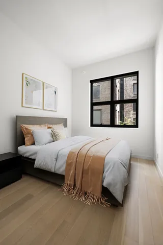 a bedroom with a bed and a large window