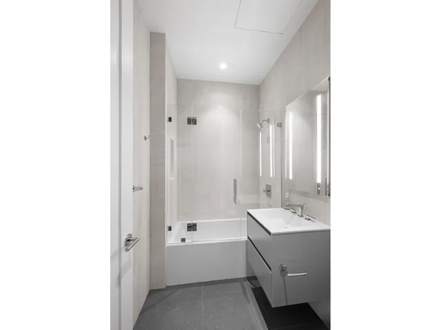 a bathroom with a double vanity sink a mirror and a bathtub