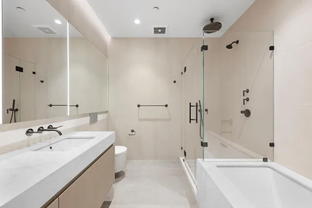 a bathroom with a bathtub shower sink vanity and a toilet