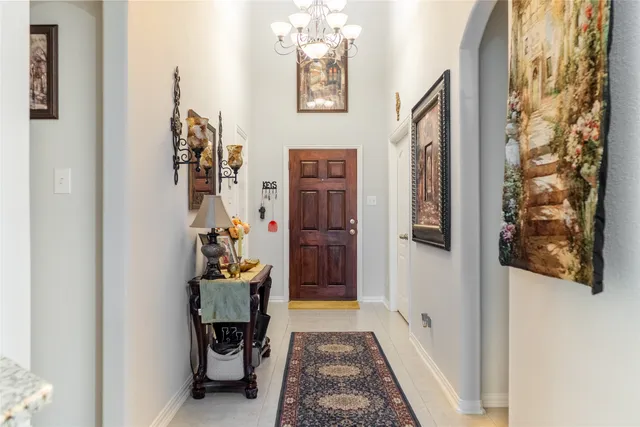 a hallway with painting on the wall and a window