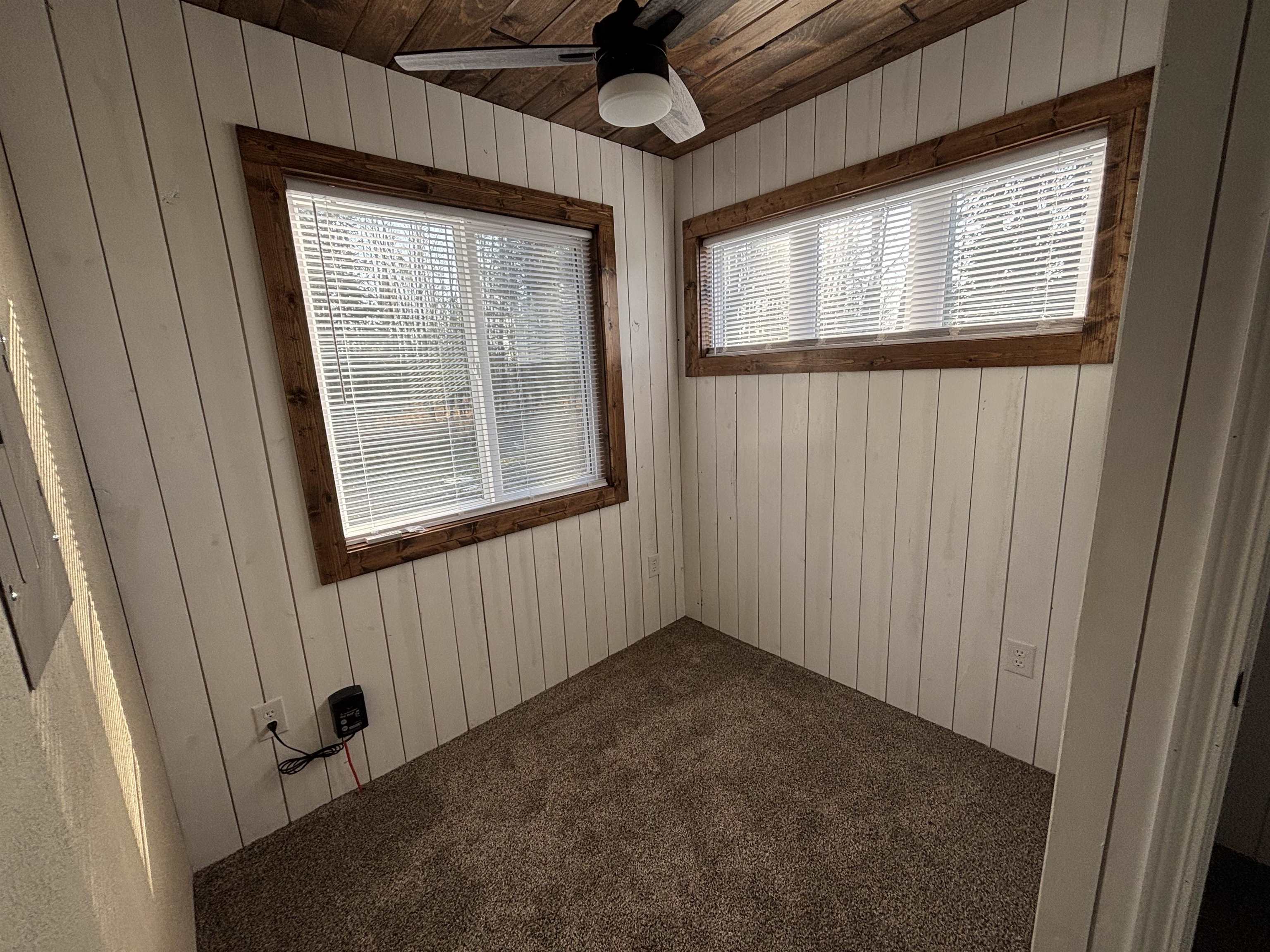 3746 South Hughes Road Hibbing, MN 55746 - Photo 4 of 10 Carpeted empty room with ceiling fan, wood walls, and wood ceiling