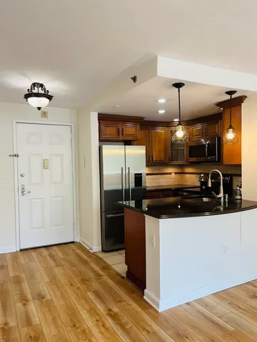 a view of a kitchen with a sink and refrigerator
