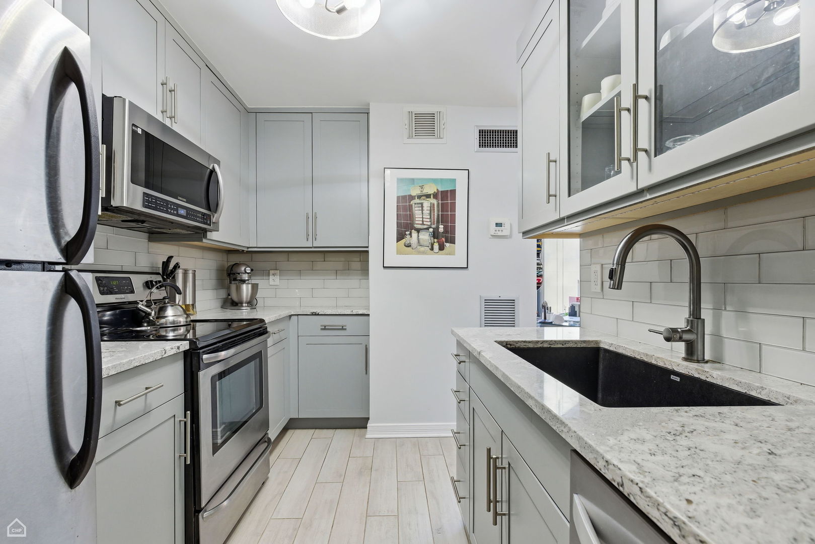 401 East Ontario Street, Unit 710 Chicago, IL 60611 - Photo 11 of 36 a kitchen with stainless steel appliances granite countertop a sink and stove top oven