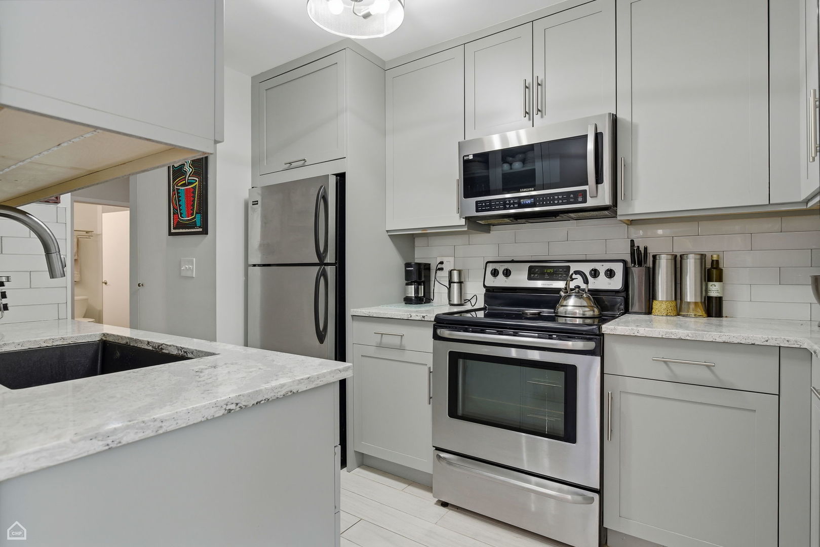 401 East Ontario Street, Unit 710 Chicago, IL 60611 - Photo 15 of 36 a kitchen with stainless steel appliances granite countertop a stove a microwave and a refrigerator