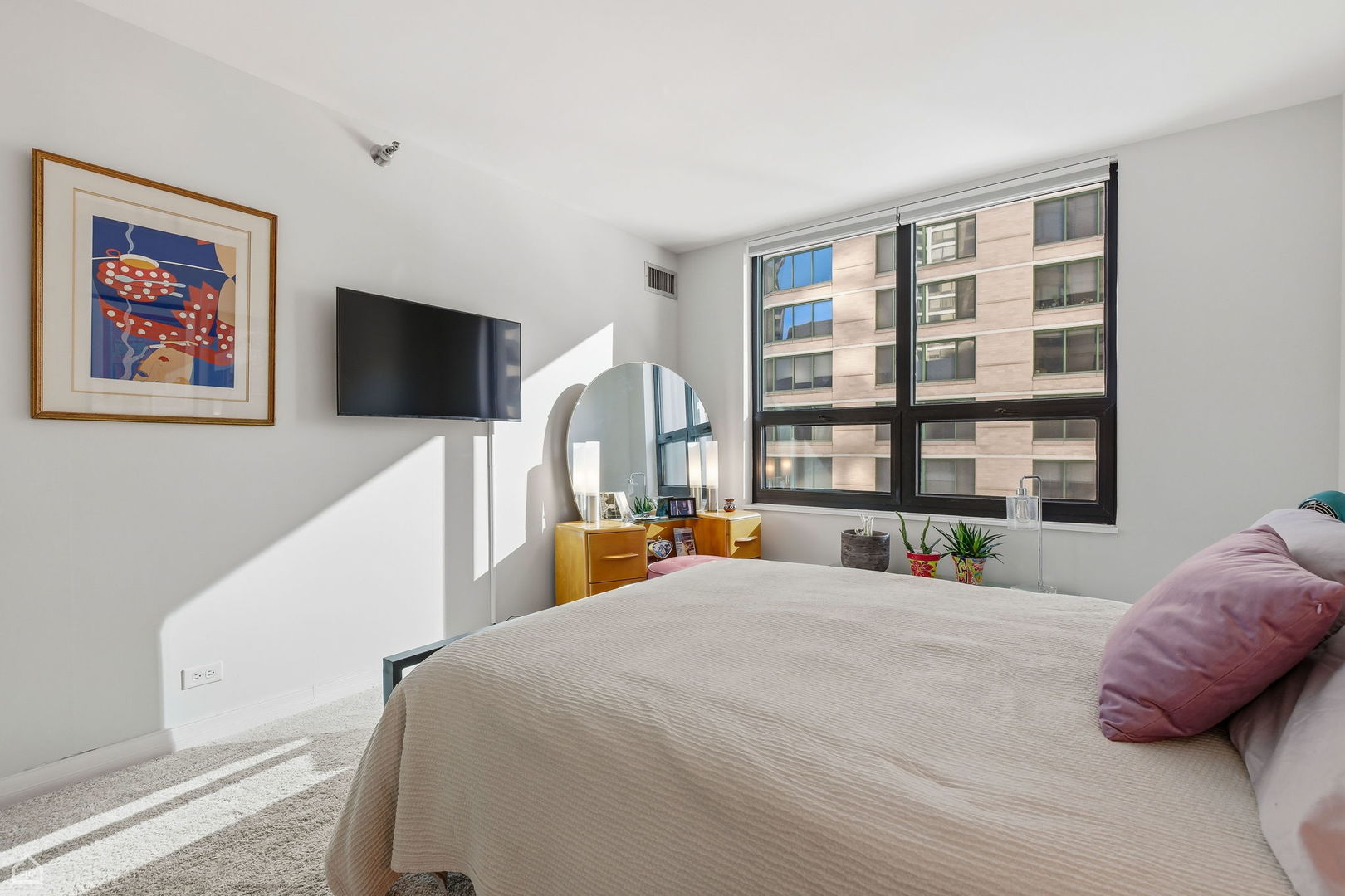 401 East Ontario Street, Unit 710 Chicago, IL 60611 - Photo 17 of 36 a bedroom with a large bed and a flat screen tv