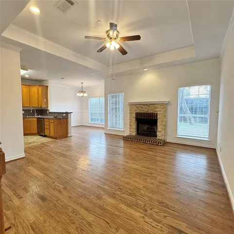 wooden floor fireplace and windows in an empty room