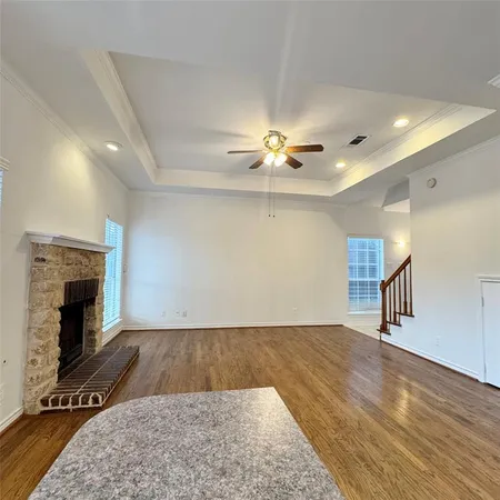 wooden floor fireplace and windows in an empty room