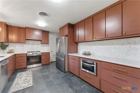 a kitchen with stainless steel appliances and cabinets
