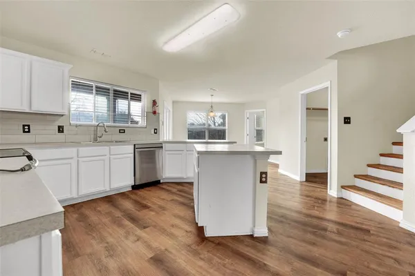 a kitchen with a sink cabinets and wooden floor