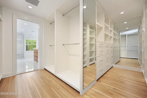 a view of walk in closet with wooden floor