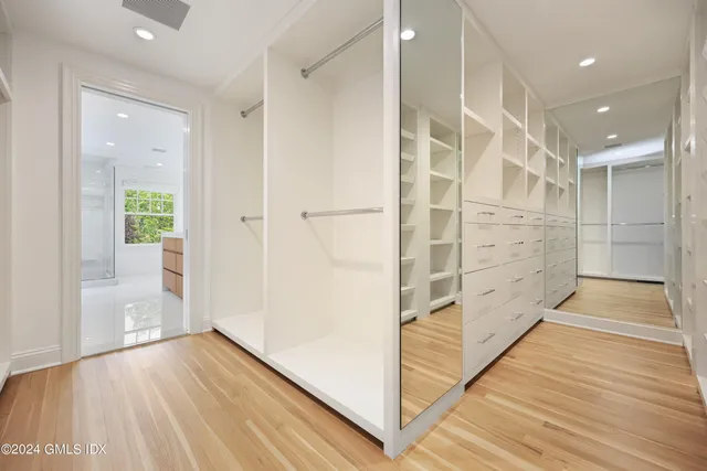 a view of walk in closet with wooden floor