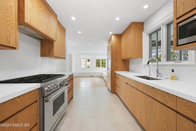 a large kitchen with stainless steel appliances granite countertop a lot of counter space and a sink