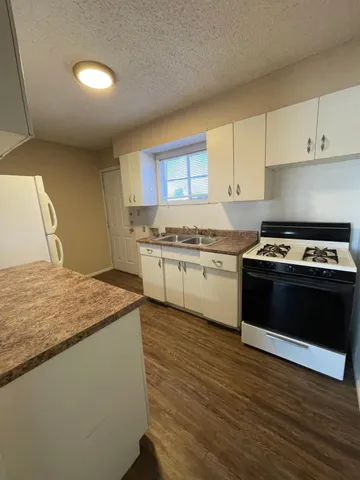 a kitchen with stainless steel appliances granite countertop a stove a sink and a microwave
