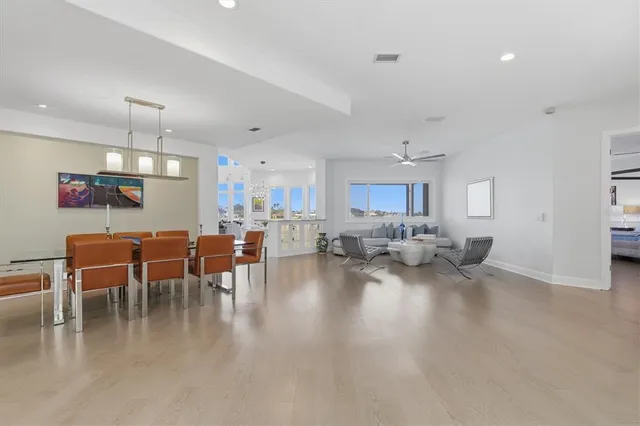 a living room with couches a coffee table and dresser with wooden floor