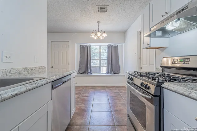a kitchen with a stove sink and cabinets
