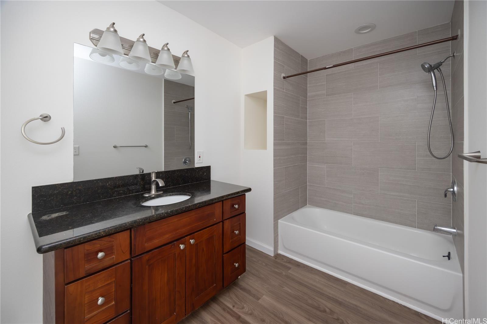 87-176 Maipalaoa Road, Unit Q38 Waianae, HI 96792 - Photo 11 of 18 a bathroom with a granite countertop sink a mirror and a bathtub