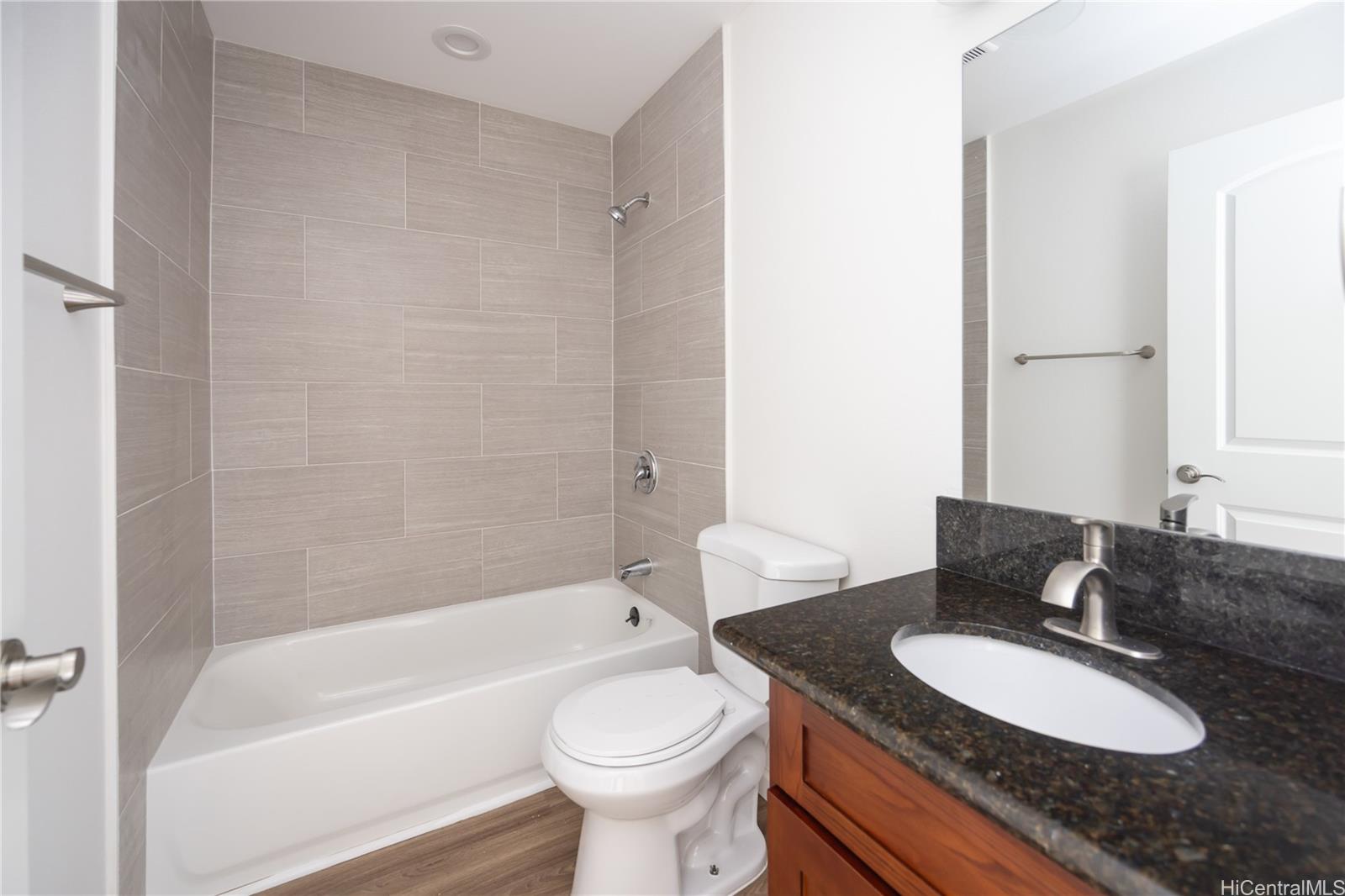 87-176 Maipalaoa Road, Unit Q38 Waianae, HI 96792 - Photo 12 of 18 a bathroom with a granite countertop sink toilet a mirror and bathtub
