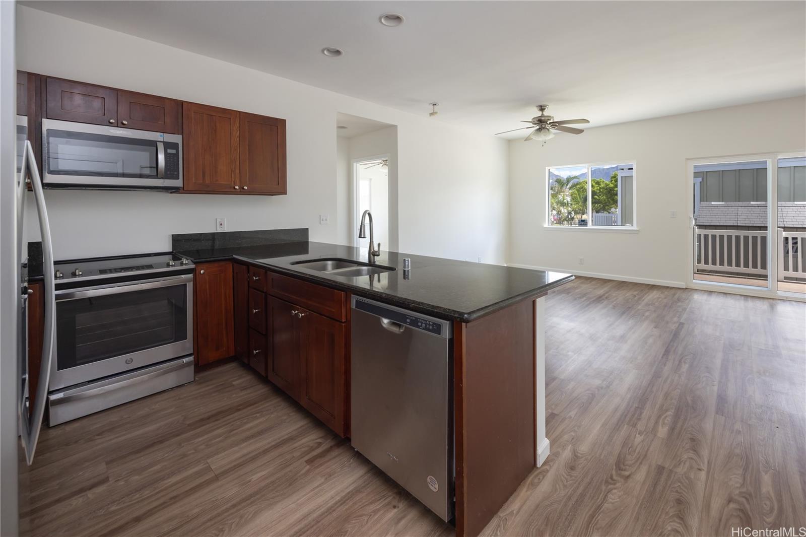 87-176 Maipalaoa Road, Unit Q38 Waianae, HI 96792 - Photo 2 of 18 a kitchen with stainless steel appliances granite countertop a stove a sink and a microwave