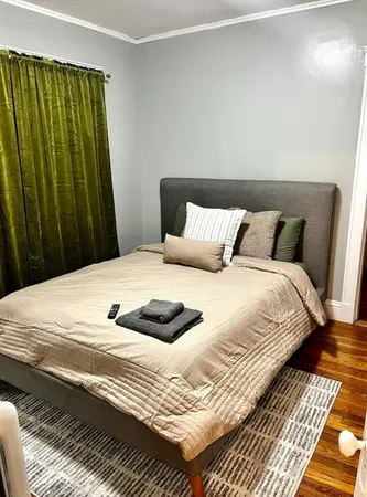a large bed sitting in a bedroom next to a wooden cabinet