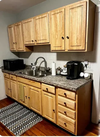 a kitchen with granite countertop a sink a stove and cabinets